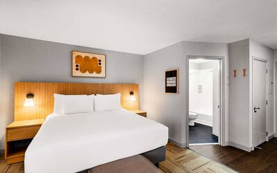 Double bed guest room in Sonesta Simply Suites Austin South, featuring art on the wall and an ensuite bathroom.