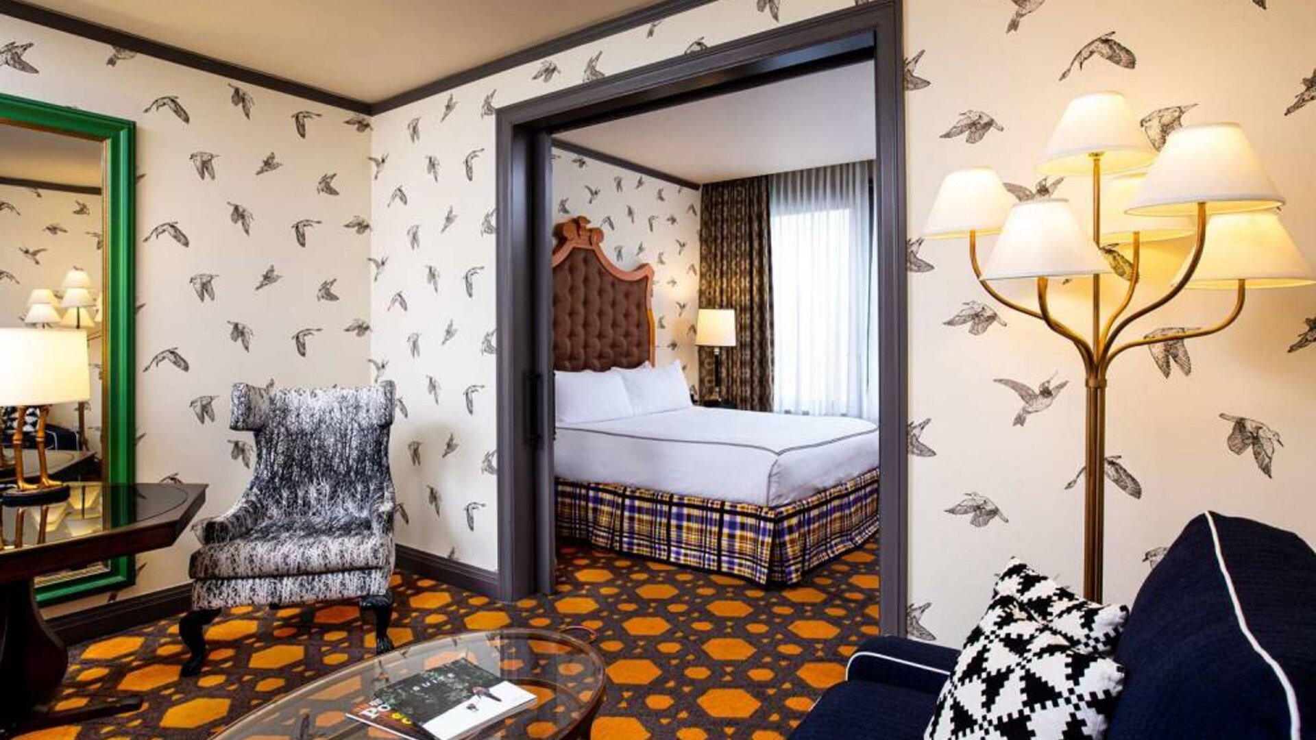 Double bed guest room in Royal Sonesta Portland Downtown, including a living area with sofa, coffee tables, and a chair.