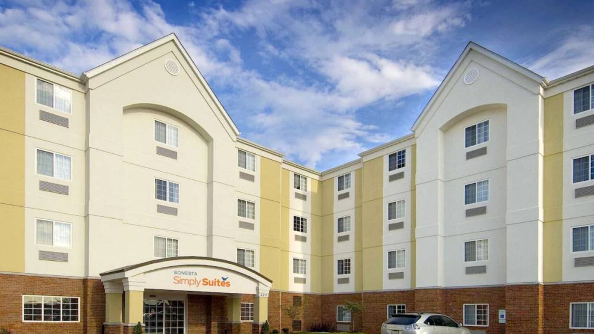 The hotel’s exterior has parking close to the front door, which features potted plants and has the Sonest Simply Suites name above it.