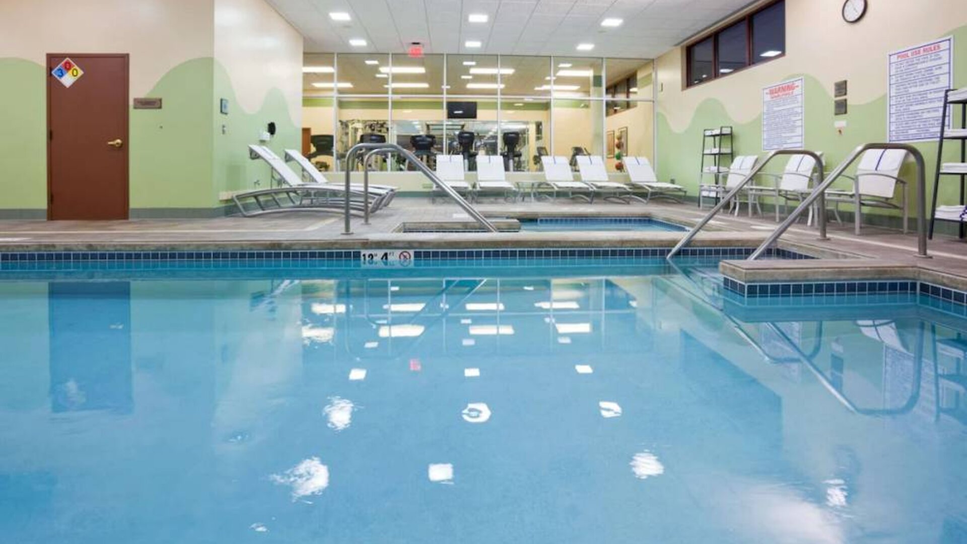 The indoor pool at Sonesta Milwaukee West Wauwatosa has an adjacent hot tub, sun loungers by the side, and is next to the fitness center.