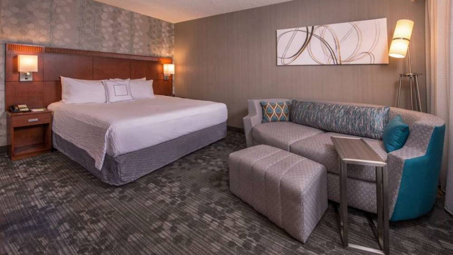 Sonesta Select Columbia double bed guest room, with art on the wall and a sofa.