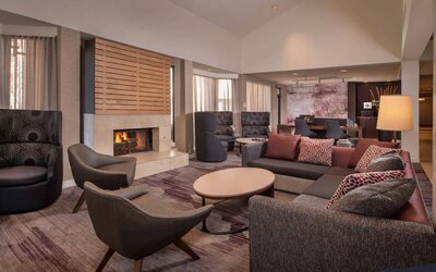 Sonesta Select Columbia’s lobby lounge is furnished with a large sofa and comfy chairs, coffee tables, and a fireplace.