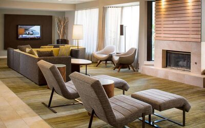 Sonesta Select Boca Raton’s lobby lounge has sofas, chairs, and reclined seats, plus coffee tables, a fireplace, and a wall-mounted television.