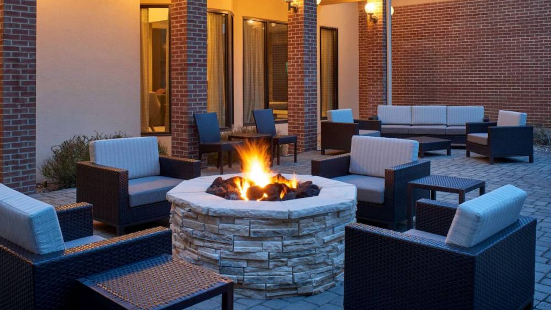 Sonesta Select Indianapolis Carmel’s patio features a fire pit and armchairs, plus coffee tables and sofa seating.