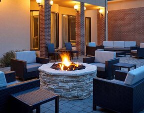 Sonesta Select Indianapolis Carmel’s patio features a fire pit and armchairs, plus coffee tables and sofa seating.