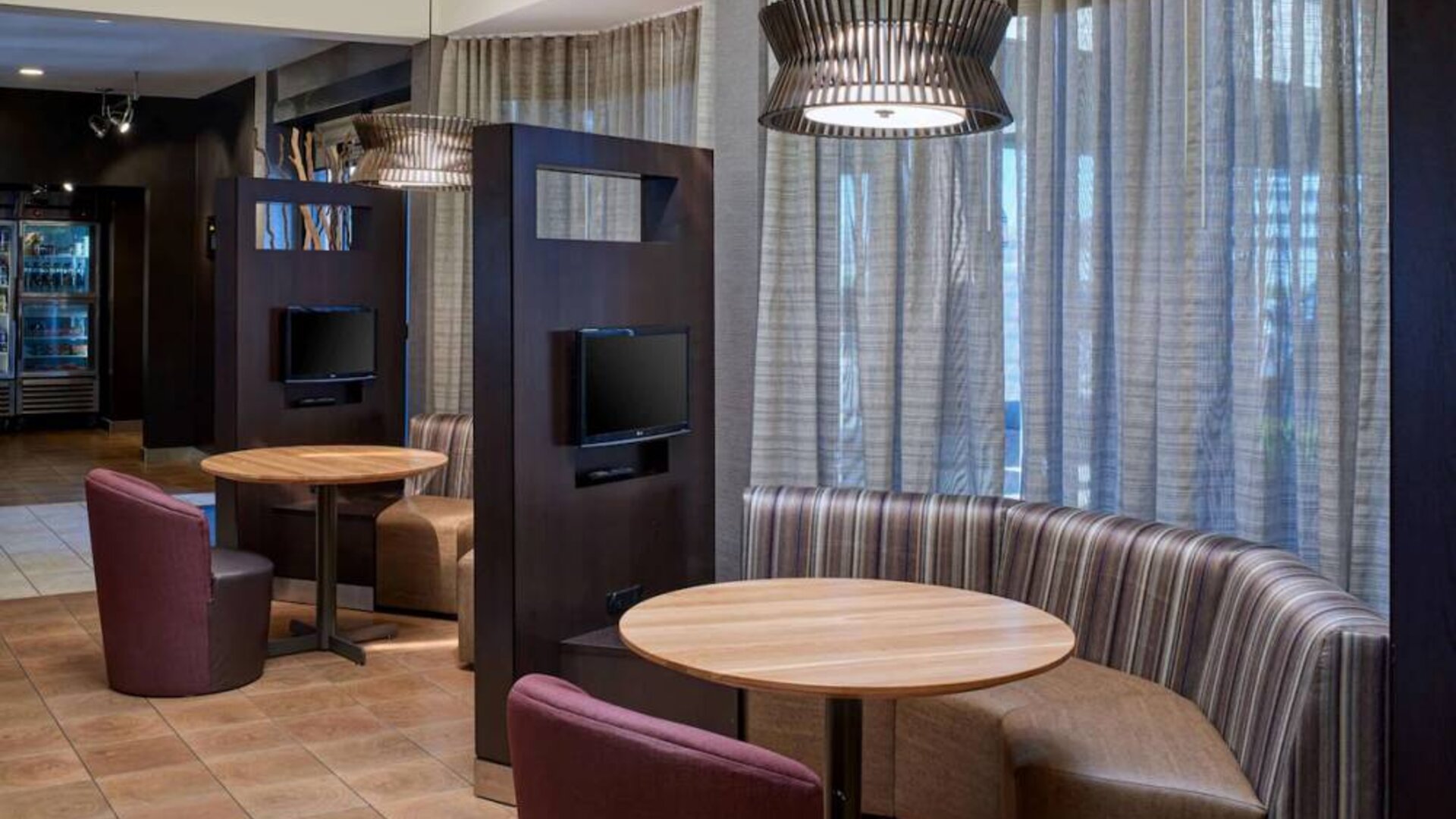 Sonesta Select Indianapolis Carmel’s media pods each feature a TV, coffee table, and comfortable seating next to a window.