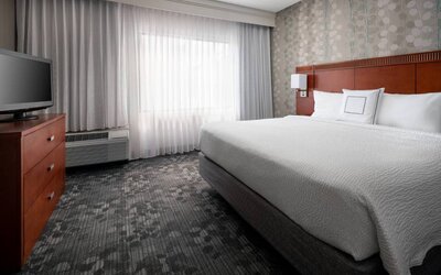 Double bed guest room in Sonesta Select Phoenix Camelback, featuring window and widescreen television.