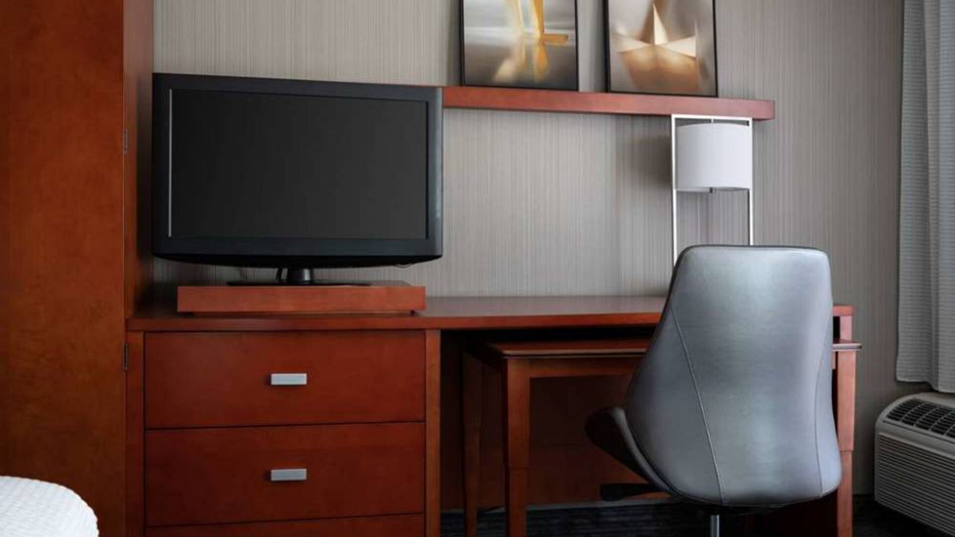 Sonesta Select Phoenix Camelback guest room workspace, including desk, chair, and lamp, plus a TV.