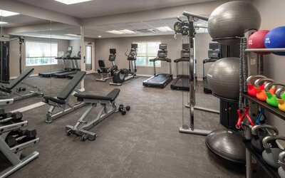 The fitness center at Sonesta ES Suites Fairfax Fair Lakes is equipped with dumbbells, kettlebells, gym balls, and assorted exercise machines.