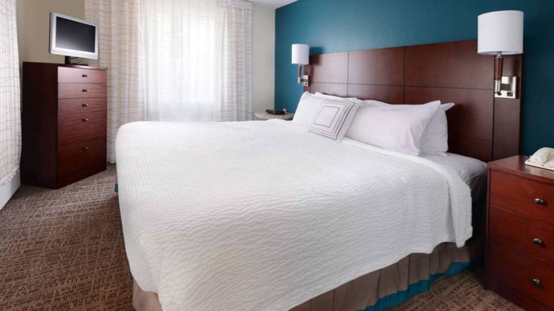 Double bed guest room in Sonesta ES Suites Dallas Medical Market Center, featuring a television and a window.