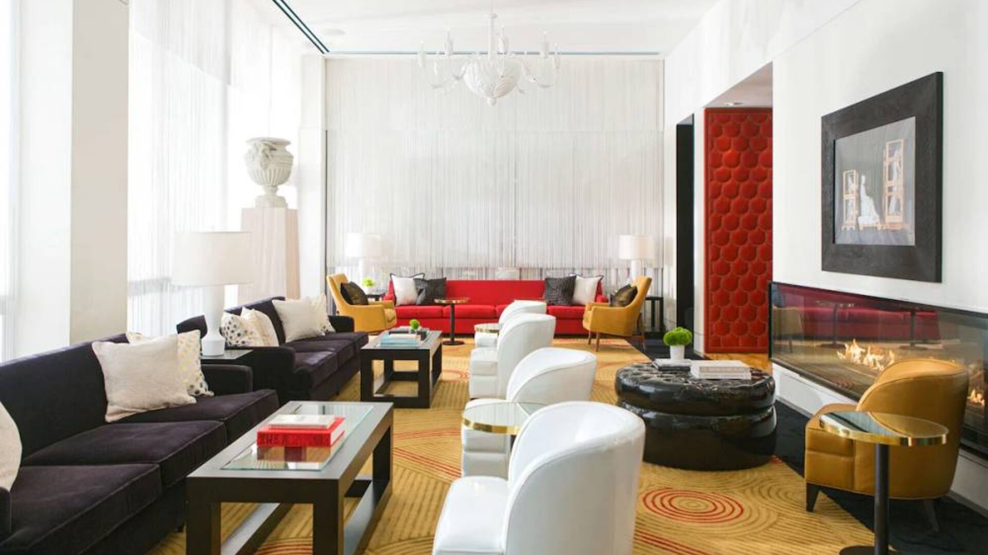 The lounge in Royal Sonesta Chicago River North has comfy chairs and numerous sofas, coffee tables, and large windows creating plenty of natural light.