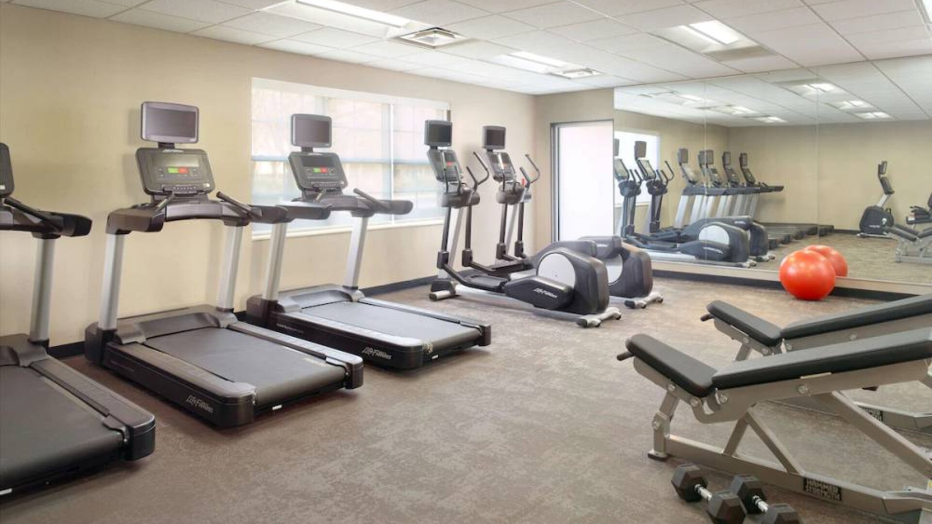 Sonesta ES Suites Raleigh Durham Airport Morrisville’s fitness center is equipped with free weights, benches, and various exercise machines.