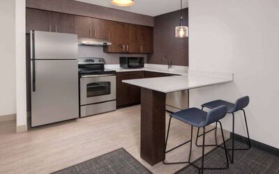 Sonesta ES Suites Atlanta Alpharetta North Point Mall guest room kitchen, fitted with fridge-freezer, microwave, oven, and table.