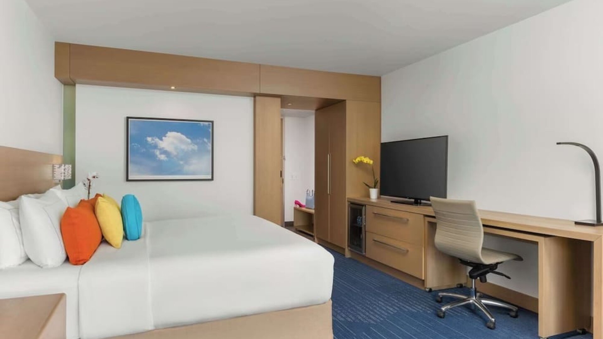 King bed with TV, work station, and natural light at The Art Hotel Denver.