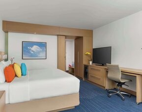 King bed with TV, work station, and natural light at The Art Hotel Denver.