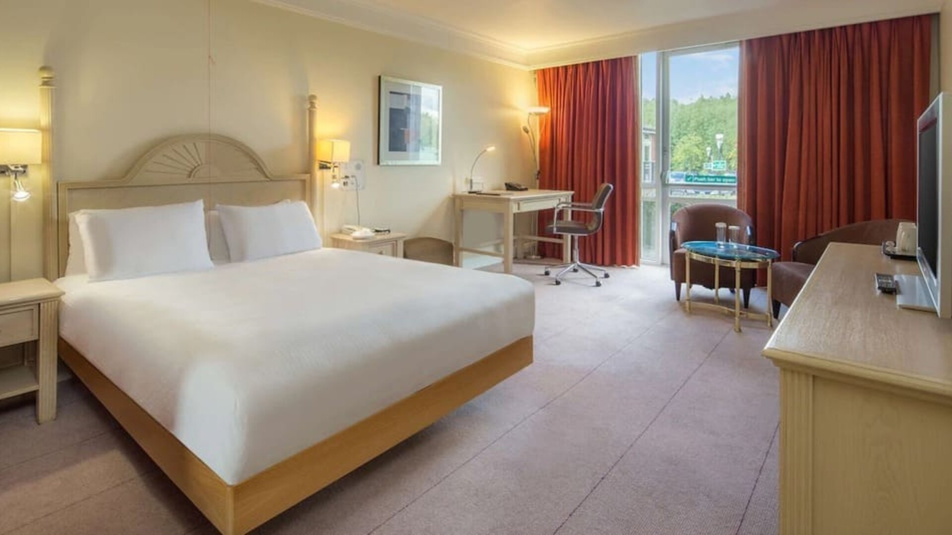 King bed with TV and natural light at Hilton Leicester.