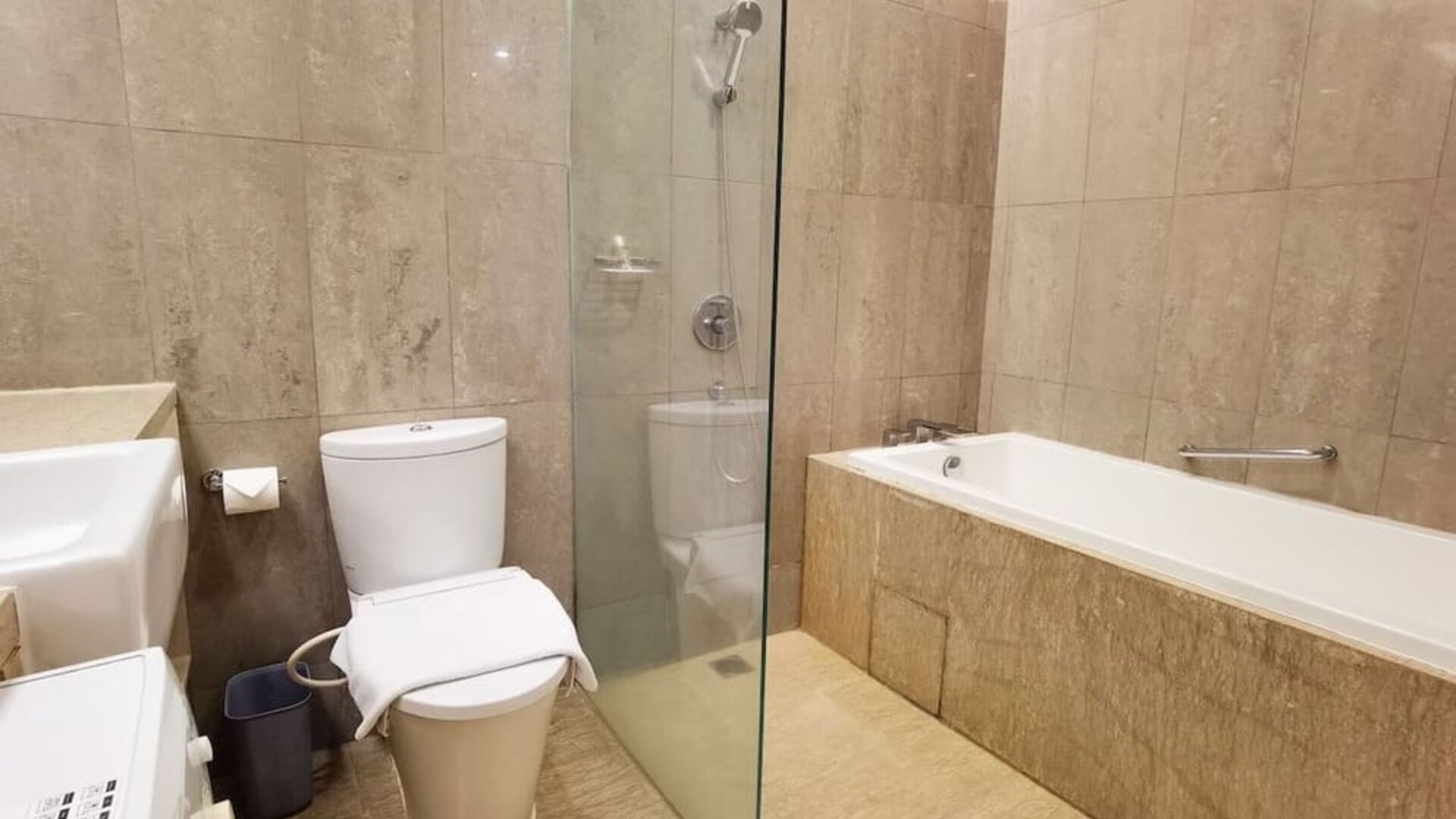 Bathroom with bath and shower at Fraser Residence Menteng Jakarta.