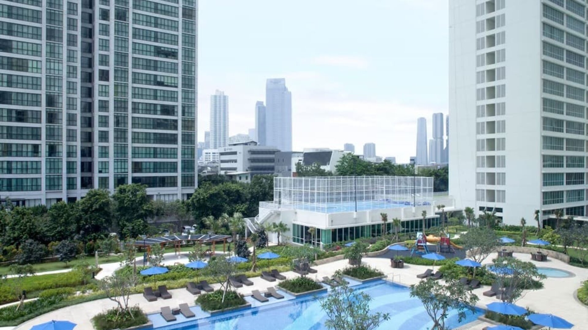 Outdoor pool with lounge chairs at Fraser Place Setiabudi Jakarta.