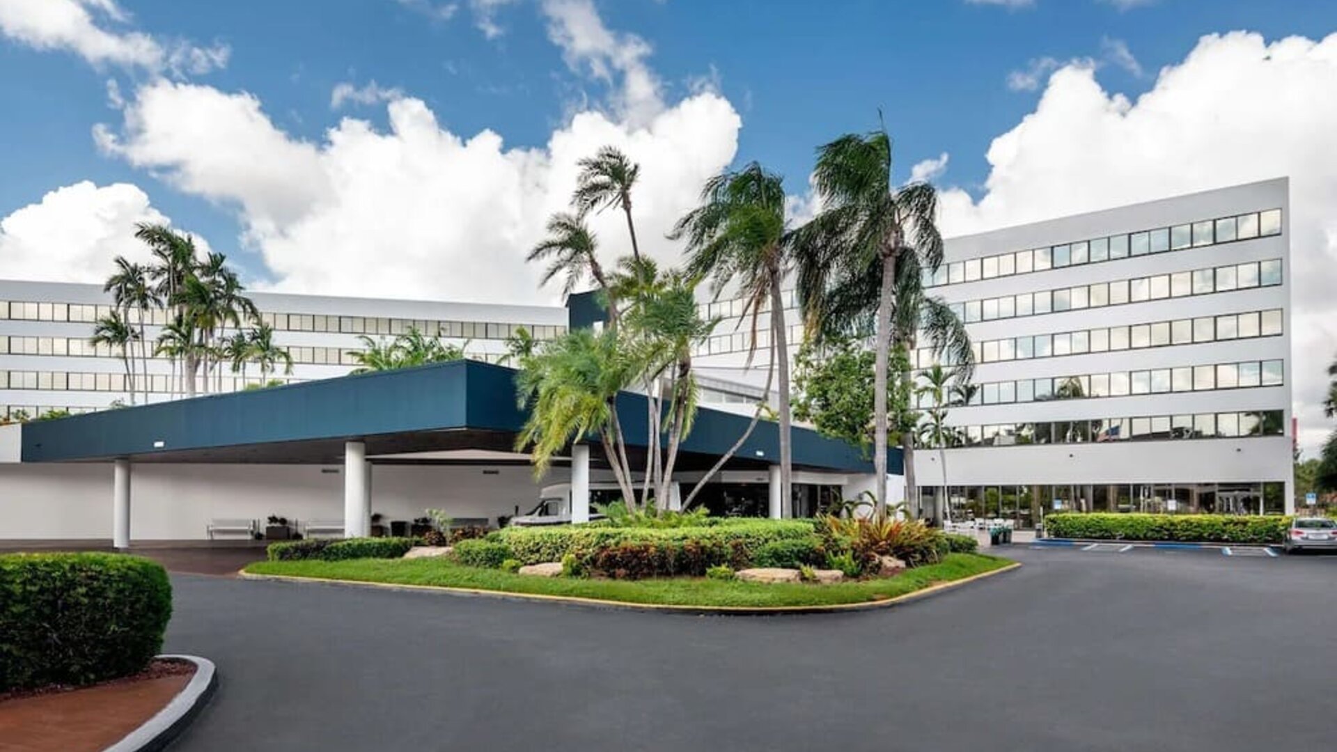 Parking and hotel exterior at Sonesta Miami Airport.