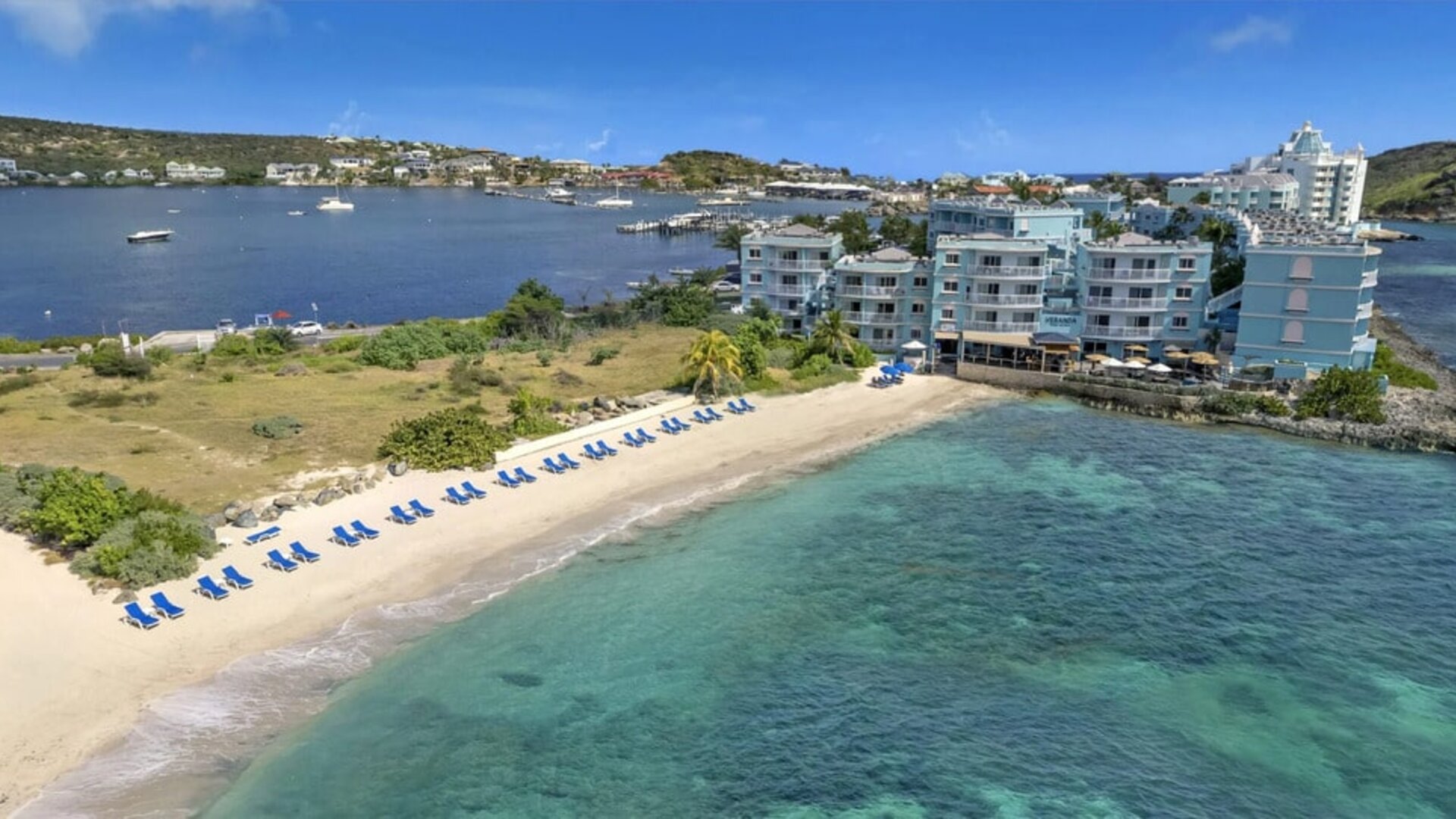 Oyster Bay Resort in St. Martin with buildings along beach and bay. 
