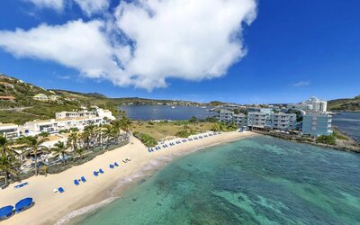 Oyster Bay Resort in St. Martin with beach chairs lined along beach. 