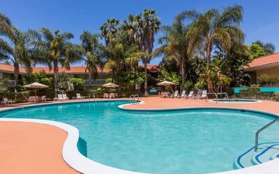 Outdoor pool with palm trees at Uptown Oasis San Jose Airport.