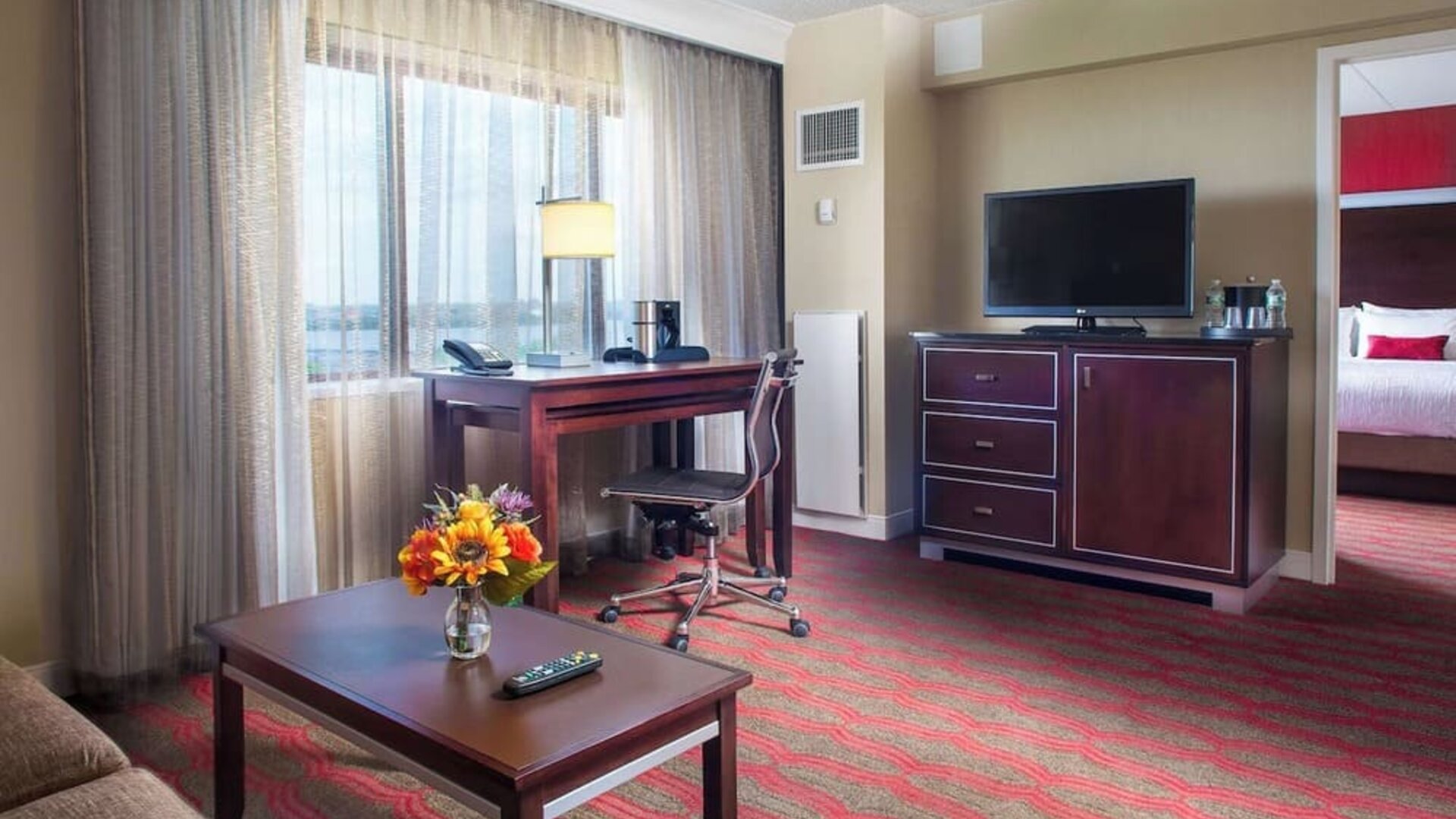 Spacious king room with lounge area at Laguardia Plaza Hotel.