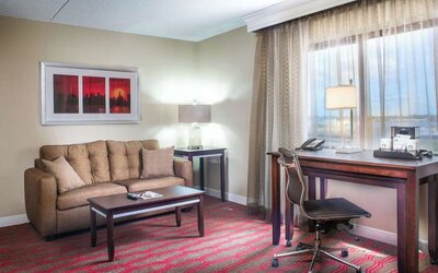 King room with lounge and work desk at Laguardia Plaza Hotel.