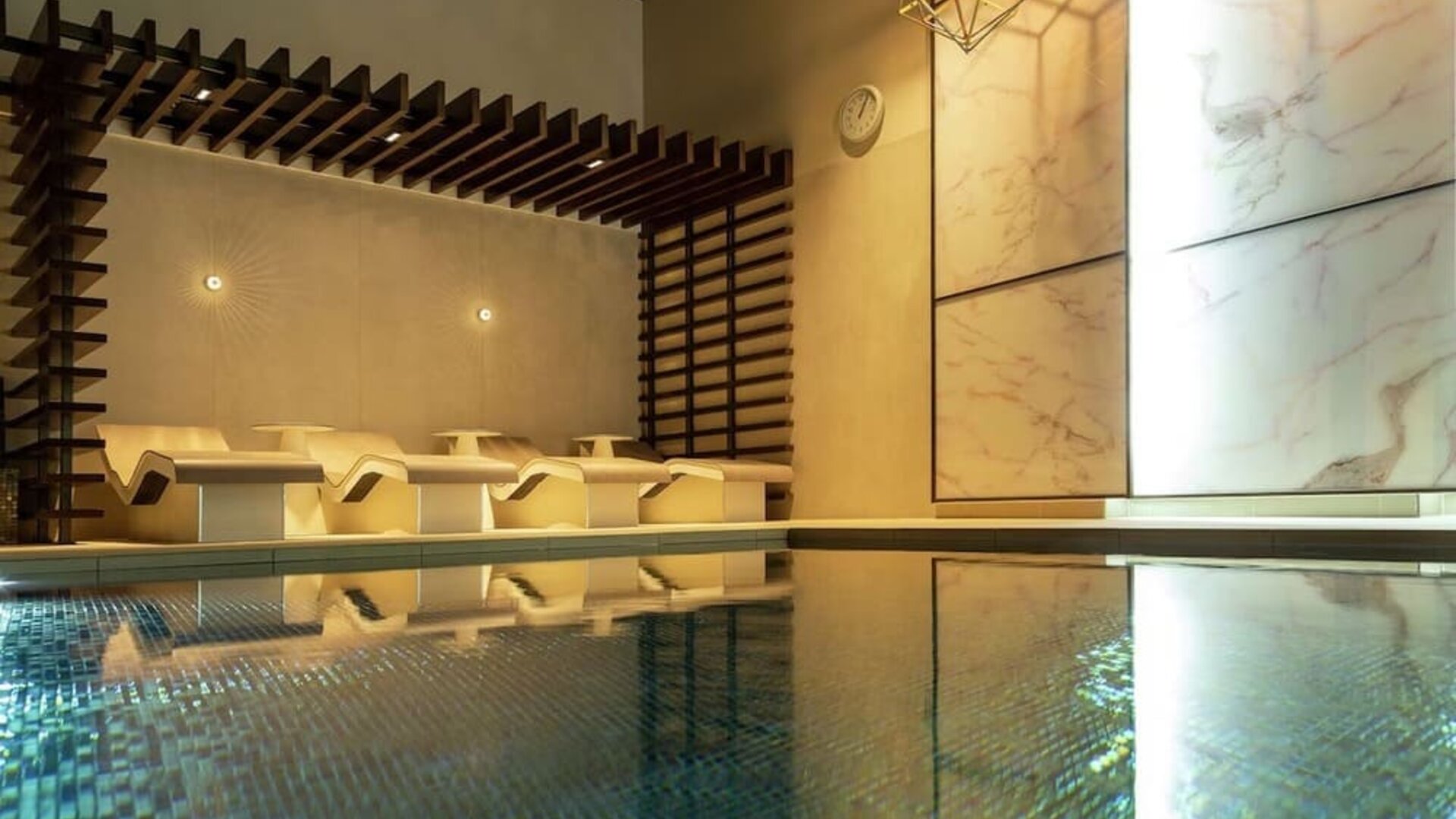 Indoor pool with chair loungers at Hilton Aberdeen TECA.