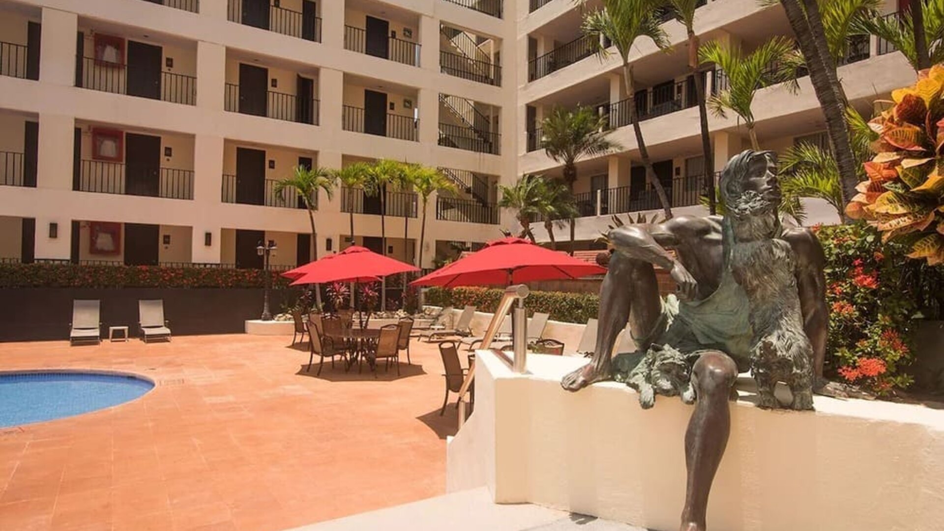 Outdoor pool and seating area at Hotel Delfin PV Beach Resort.