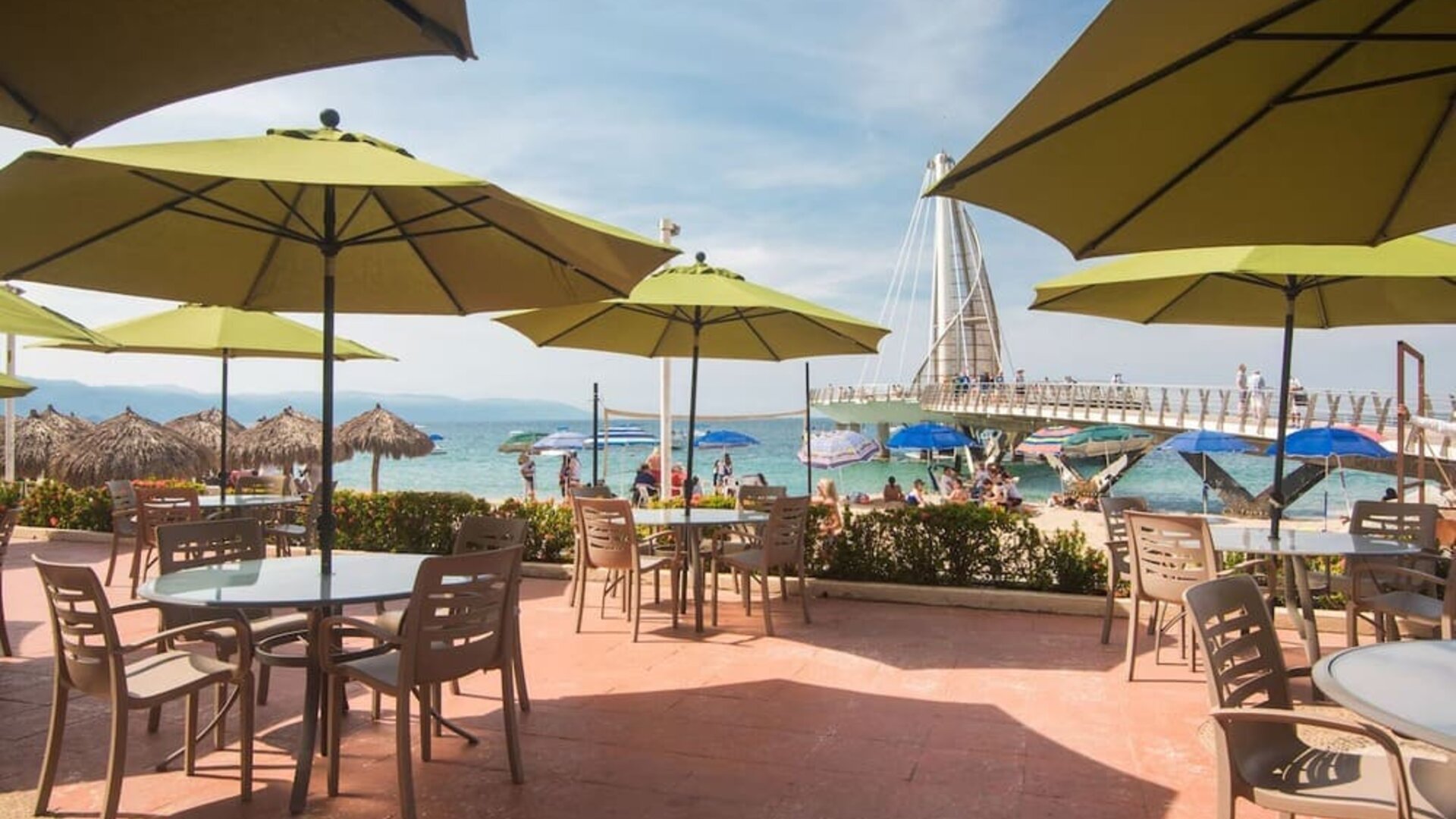 Outdoor seating with beach umbrellas at Hotel Delfin PV Beach Resort.