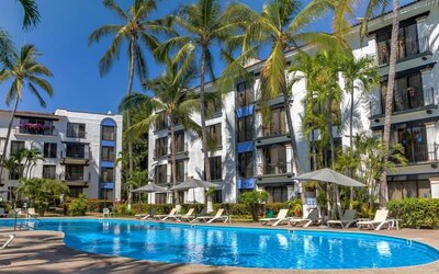 Stunning outdoor pool with palm trees at Puerto De Luna Pet Friendly & Family Suites.