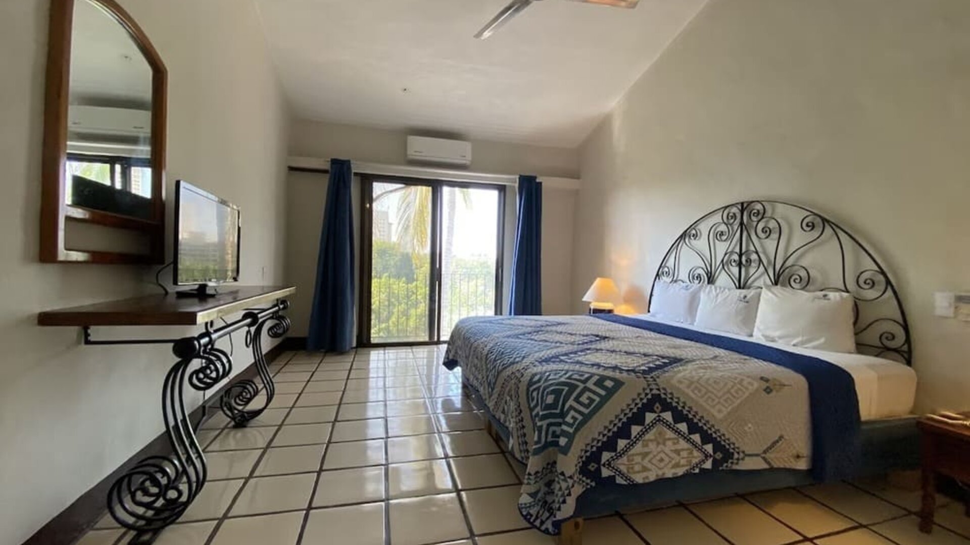 Romantic king room with natural light at Puerto De Luna Pet Friendly & Family Suites.