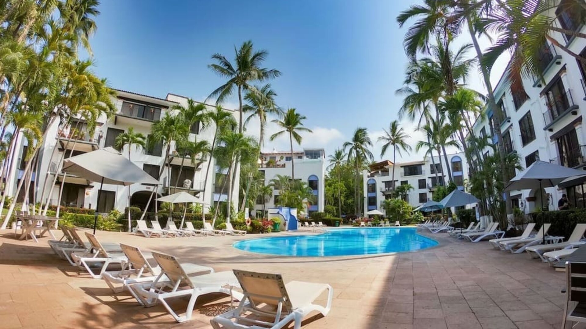 Outdoor pool with pool loungers at Puerto De Luna Pet Friendly & Family Suites.