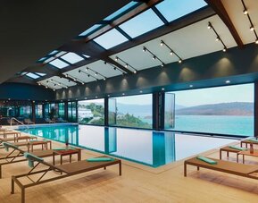 Indoor pool with loungers at Le Méridien Bodrum Beach Resort.