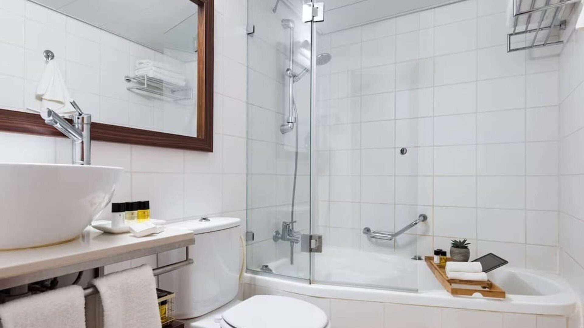 Guest bathroom with shower and bath at Prima Royale Hotel.