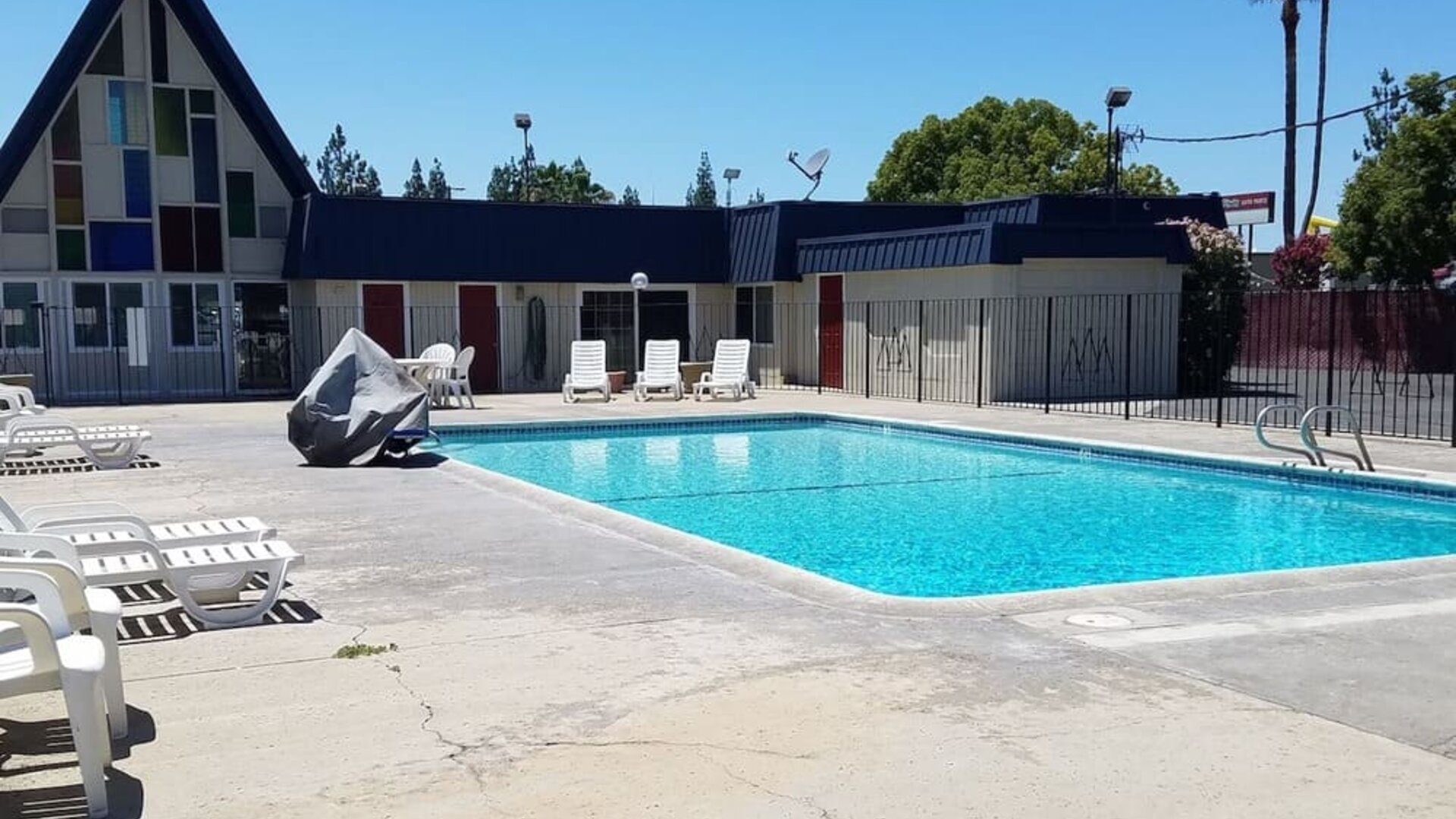Outdoor pool with loungers at Economy Inn, Fresno.