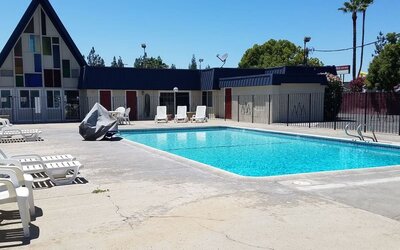 Outdoor pool with loungers at Economy Inn, Fresno.
