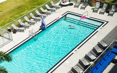 Outdoor pool with loungers at Aloft Miami Doral.
