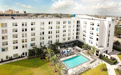 Hotel pool and hotel exterior at Aloft Miami Doral.
