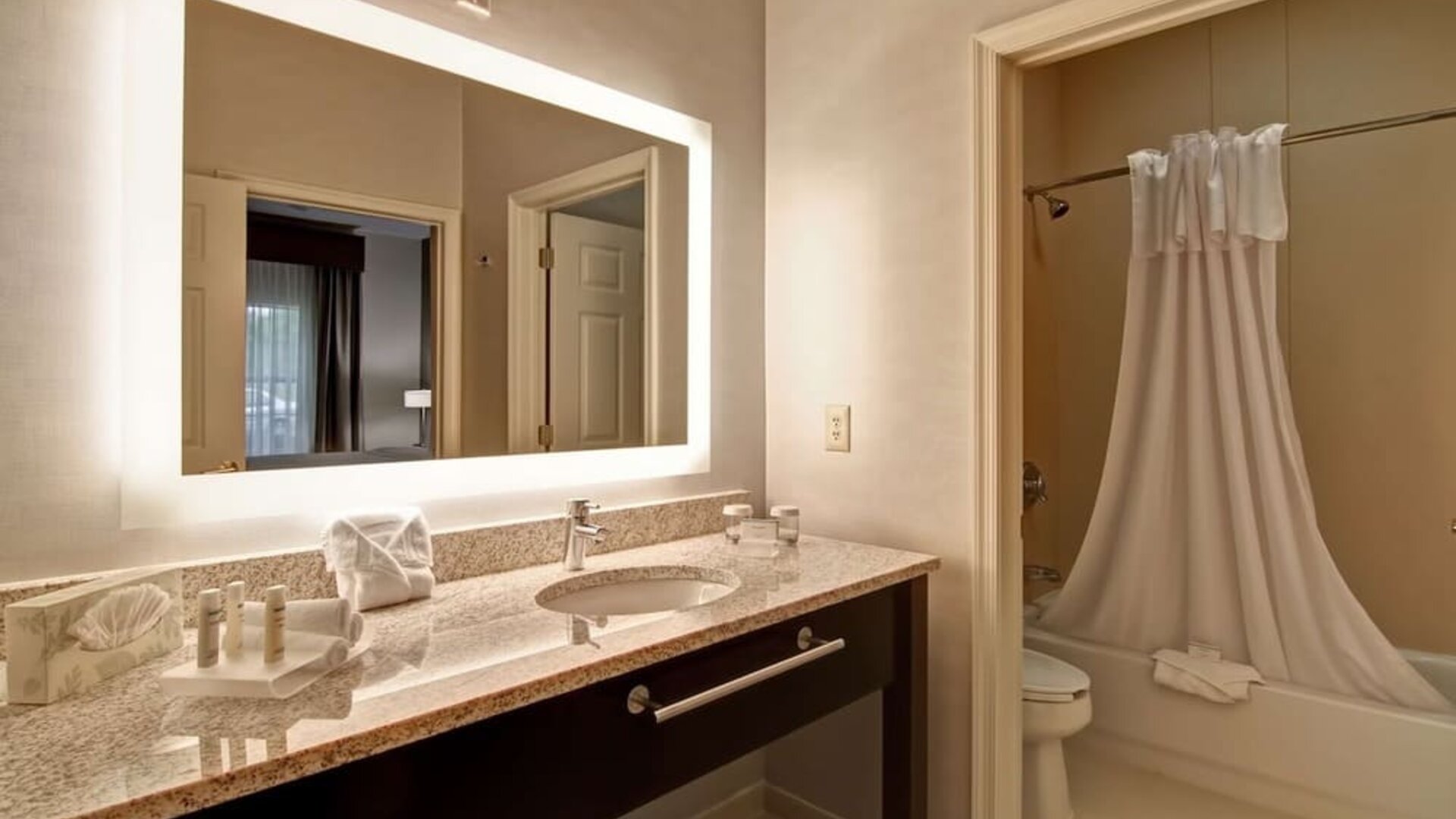 Guest bathroom with shower and tub at Homewood Suites By Hilton Newark-Cranford.