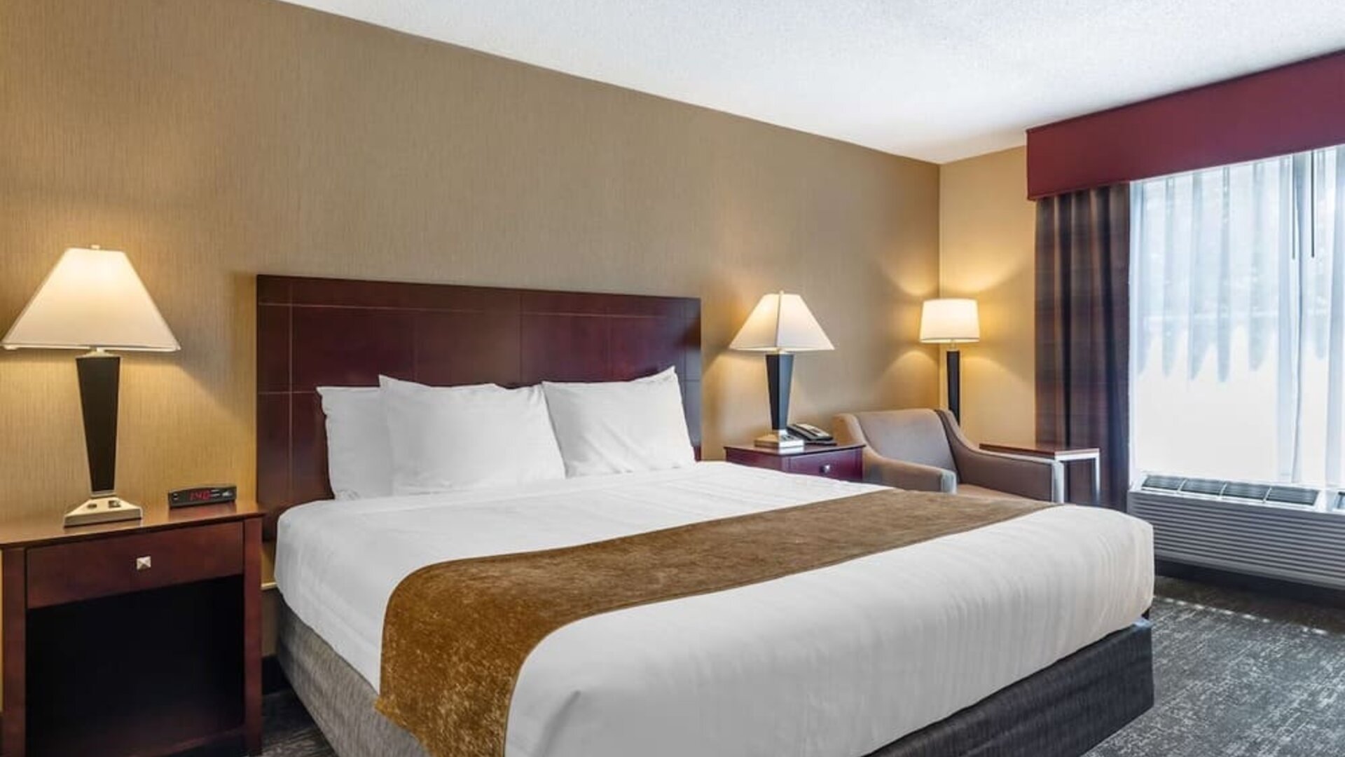 King room featuring premium bedding, bedside lighting, and a relaxing seating area at Best Western Braintree.