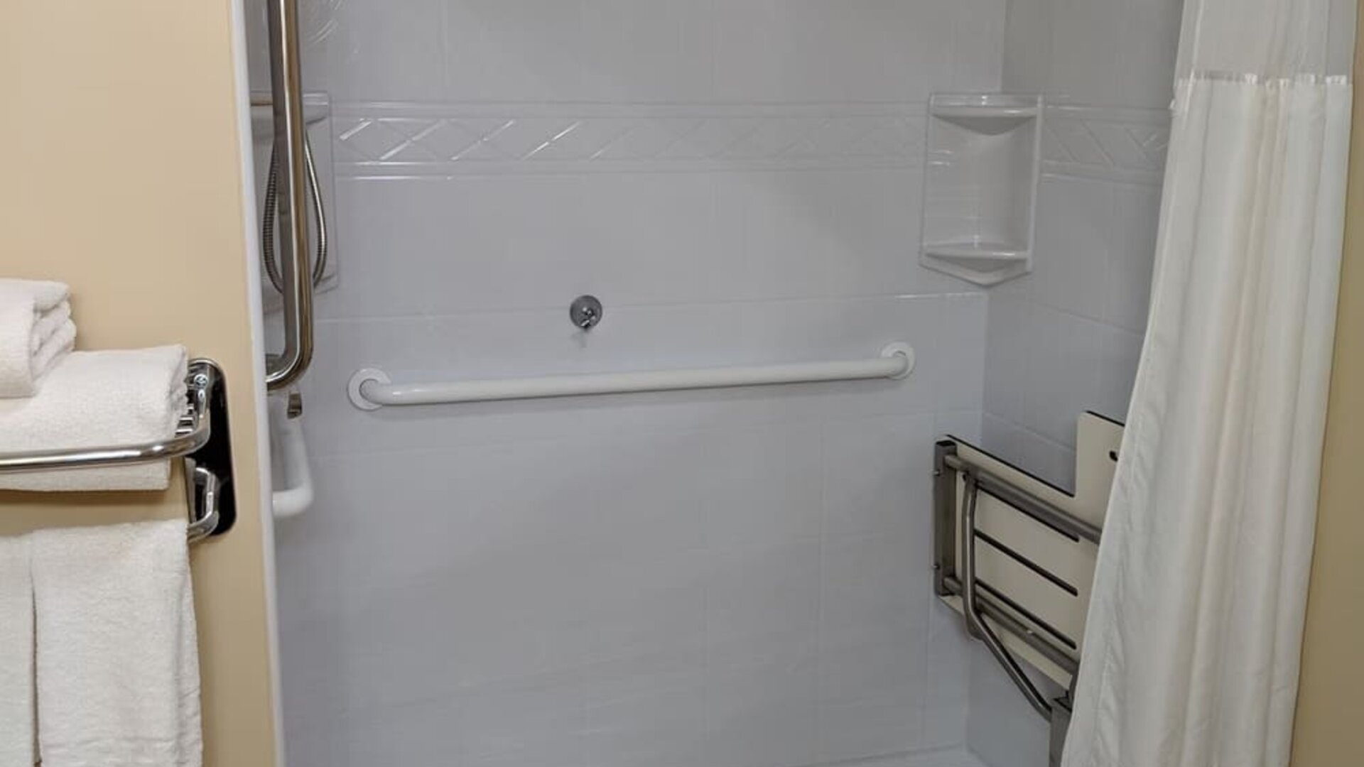 Accessible roll-in shower featuring safety grab bars, spacious layout, and mobility-friendly amenities at Best Western Braintree.