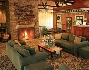 Cozy fireplace lounge featuring comfortable sofas and a warm gathering space at Sturbridge Host Hotel.