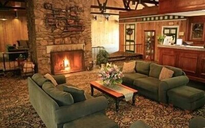 Cozy fireplace lounge featuring comfortable sofas and a warm gathering space at Sturbridge Host Hotel.