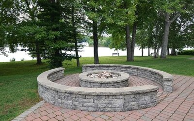 Outdoor fire pit area overlooking the waterfront, ideal for relaxing and social gatherings at Sturbridge Host Hotel.