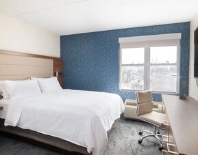Contemporary king guest room offering plush bedding, a dedicated workspace, and city views at Holiday Inn Express & Suites Boston-Cambridge.