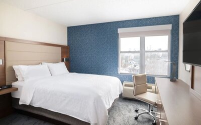 Contemporary king guest room offering plush bedding, a dedicated workspace, and city views at Holiday Inn Express & Suites Boston-Cambridge.