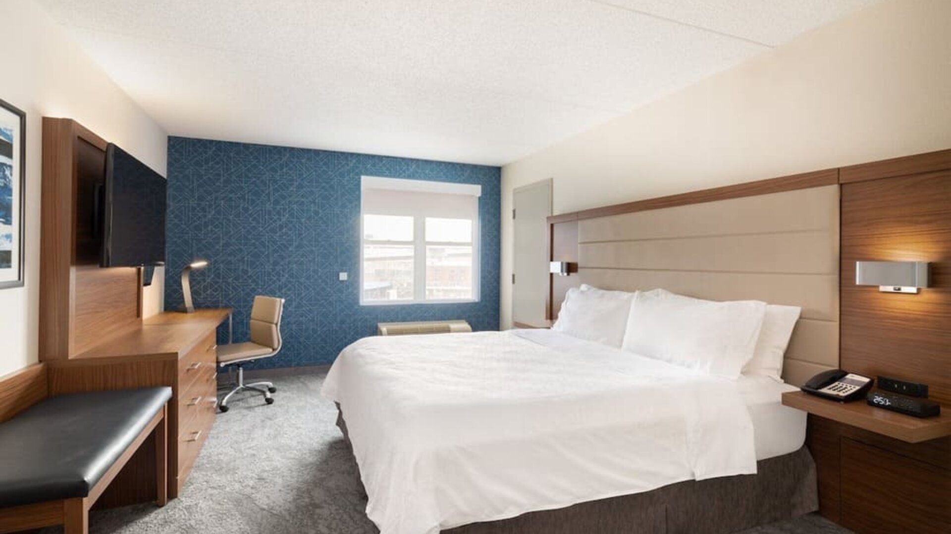 King guest room featuring premium bedding, ergonomic workspace, and thoughtfully designed amenities at Holiday Inn Express & Suites Boston-Cambridge.