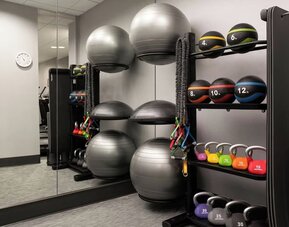 Fitness center featuring strength-training equipment, kettlebells, medicine balls, and functional fitness tools for a complete workout experience at Courtyard by Marriott Boston Brookline.